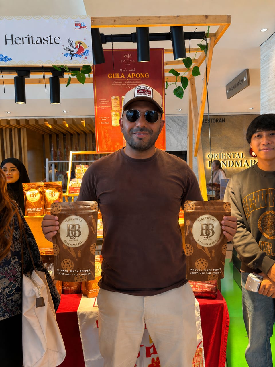 Customer holding Borneo Bites cookie pouches at popup booth