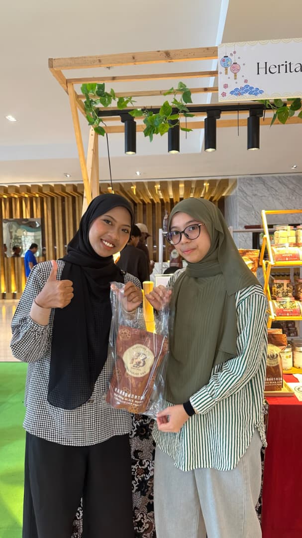 Happy customers holding a Borneo Bites pouch with thumbs up